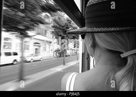 Frau gekleidet in weiss mit Stroh Hut auf eine Straßenbahn in Lissabon Stockfoto