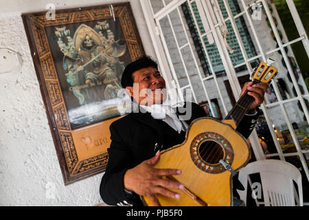 Ein mexikanischer Mariachi Musiker spielt Gitarre in der Santa Muerte (Heilige Tod) Tempel in Tepito, eine gefährliche Gegend von Mexico City, Mexiko. Stockfoto