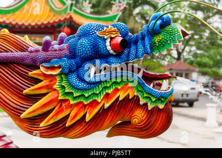 Eine schöne Nahaufnahme von einem bunten Wasser spritzen Dragon Head bei einem chinesischen Tempel. Der Wasserstrahl kommt aus seiner Zunge. Stockfoto