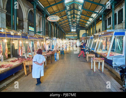 Athen, Griechenland - Juli 2, 2018. Metzger vor seinem Stände in Varvakios, zentrale Markt von Athen. Region Attika, Griechenland. Stockfoto