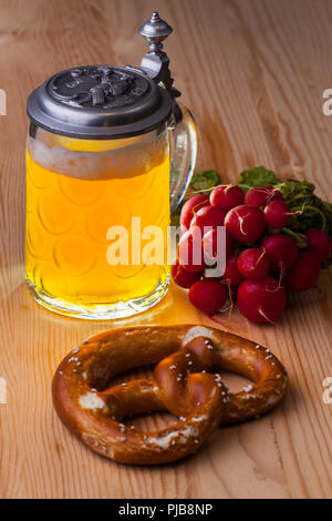 Bier, Brezeln und Radieschen auf rustikalem Holz Stockfoto