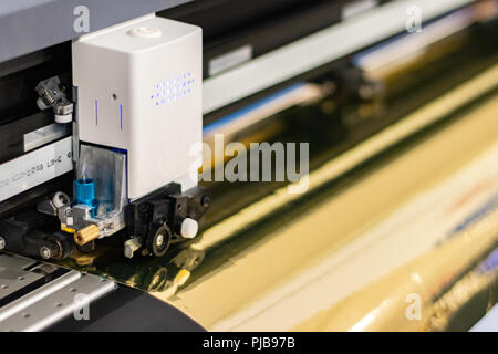 Große professionelle Drucker, Verarbeitung einer großen Skala Glänzend vinyl Roll. Stockfoto