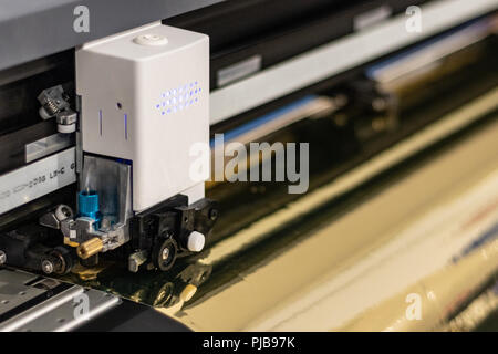 Große professionelle Drucker, Verarbeitung einer großen Skala Glänzend vinyl Roll. Stockfoto