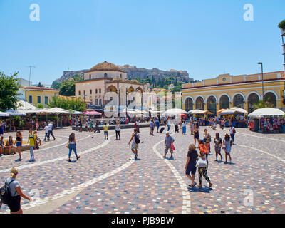 Überqueren von Monastirakiou/Monastiraki Platz mit Tzistarakis Moschee und Nordhang der Athener Akropolis im Hintergrund. Attika, Griechenland. Stockfoto