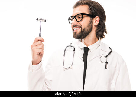 Lächelnd Arzt im weißen Kittel und Brille holding Reflexhammer isoliert auf weißem Stockfoto