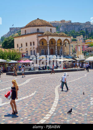 Überqueren von Monastirakiou/Monastiraki Platz mit Tzistarakis Moschee und Nordhang der Athener Akropolis im Hintergrund. Attika, Griechenland. Stockfoto