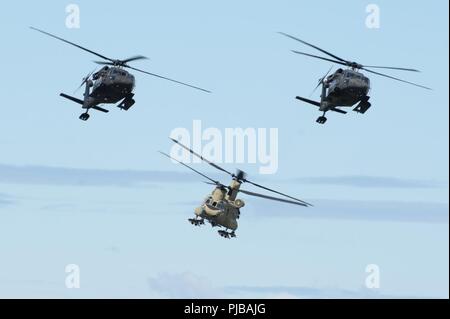 Zwei Alaska Army National Guard UH-60 Black Hawks und ein US-Armee Alaska CH-47 Chinook Ansatz der Flight Line als Teil der Joint Forces Demonstration während der Arctic Thunder Open House bei Joint Base Elmendorf-Richardson, Alaska, 1. Juli 2018. Diese alle zwei Jahre stattfindende Veranstaltung bewirtet durch JBER ist einer der grössten im Land und einer der führenden Antenne Demonstrationen in der ganzen Welt. Die Veranstaltung bietet mehrere Interpreten und Boden wirkt die JBER Joint Forces, US Air Force F-22 und US Air Force Thunderbirds Demonstrationen Teams, Juni 30 - Juli 1. Stockfoto