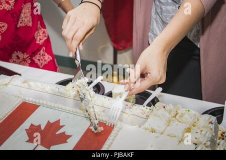 JOINT BASE Pearl Harbor - HICKAM, Hawaii (Juli 01, 2018) Das Personal vom Sheraton Princess Kaiulani Hotel in Hololulu, Hawaii, anwesenden Mitglieder der Kanadischen Streitkräfte Kontingent in den Rand des Pazifik (Rimpac) Übung mit einem Kuchen in Kanada 151. Geburtstag am Canada Day zu comemmorate teilnehmen. 25 Nationen, 46 Schiffe, 5 U-Boote, über 200 Flugzeuge und 25.000 Angestellte beteiligen sich an Rimpac vom 27. Juni bis 2. August in und um die hawaiischen Inseln und Südkalifornien. Die weltweit größte internationale maritime Übung RIMPAC bietet eine einzigartige Ausbildung Chancen Stockfoto