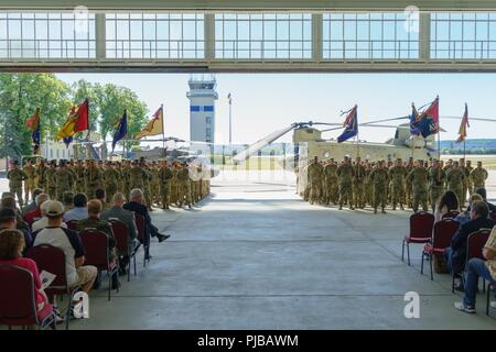 Soldaten der 1. Luft Kavallerie Brigade, 1.Kavallerie Division, von Fort Hood, Texas (Bildung), Schulter mit Soldaten des 4 Combat Aviation Brigade stehen, 4.Infanterie Division, aus Fort Carson, Colo. Als U.S. Army Europe Führer und die Illesheim, Deutschland Gemeinschaft sammeln für eine Übertragung der Autorität Zeremonie bei Storck Kasernen in Deutschland gehalten, 2. Juli 2018. "Iron Eagle" Soldaten der 4.CAB Erben die Mission Verantwortung vom 1. ACB für die Luftfahrt Maßnahmen zur Unterstützung der Atlantischen lösen, eine in den USA bemühen sich NATO-Verpflichtungen durch Drehen US-bas erfüllen Stockfoto