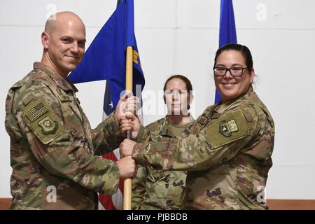 Oberst Scott Gibson, 407 Air Expeditionary Gruppenkommandant und Presiding Officer, präsentiert die 407 Expeditionary Communications Squadron guidon, Maj. Maria Kuconis bei einem Befehl Zeremonie an einem geheimen Ort im Südwesten Asien Juli 1, 2018. Oberstleutnant Charlie Grover aufgegeben Befehl des Geschwaders zu Kuconis während der Zeremonie. Stockfoto