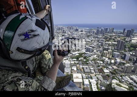 HONOLULU, Hawaii (2. Juli 2018) Mass Communication Specialist 2. Klasse Travis Litke, Commander, U.S. dritte Flotte zugeordnet, schießt Bilder von einem MH-60S Sea Hawk Hubschrauber, Hubschrauber Meer Combat Squadron 8 zugewiesen, während der Rand des Pazifik (Rimpac) 2018 Übung, Juli 2. 25 Nationen, 46 Schiffe, 5 U-Boote, über 200 Flugzeuge und 25.000 Angestellte beteiligen sich an Rimpac vom 27. Juni bis 2. August in und um die hawaiischen Inseln und Südkalifornien. Die weltweit größte internationale maritime Übung RIMPAC bietet eine einzigartige Ausbildung während der Förderung und Stockfoto