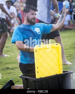 Ein Mitarbeiter mit der Marine Corps Base Hawaii (MCBH) Marina wirft eine Wasser-ballon und verwendet die Abdeckung während einer Wasser Balloon Fight Wettbewerb während der "Marina Fest", MCBH, 3. Juli 2018. Die Veranstaltung mit verschiedenen Formen der Unterhaltung, darunter mehrere Wettbewerbe und ist offen für Mitglieder, Familien und ausländischen Militärs derzeit an den Rand der Pazifischen Übung 2018. Stockfoto