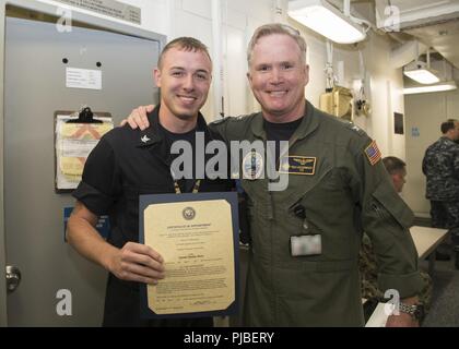 NORFOLK, Virginia (9. Juli 2018) Hospital Corpsman 2. Klasse Aaron Puffenbarger, von Sugar Grove, West Virginia, USS Gerald R. Ford's (CVN 78) Medizinische Abteilung zugewiesen, erhält seine Ernennungsurkunde in den Rang eines Petty Officer Second class von Kapitän Richard McCormack, Ford's kommandierender Offizier. Puffenbarger war nach seiner Auswahl für die verdienstvolle Förderung Programm gefördert. Stockfoto