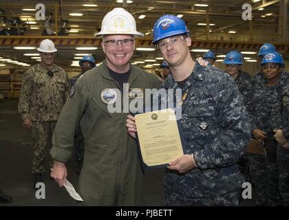 NORFOLK, Virginia (9. Juli 2018) Der Bootsmann Mate 2. Klasse Patrick Fitzgerald, von Washingtonville, New York, zu USS Gerald R. Ford's (CVN 78) deck Abteilung zugewiesen, erhält seine Ernennungsurkunde in den Rang eines Petty Officer Second class von Kapitän Richard McCormack, Ford's kommandierender Offizier. Fitzgerald war nach seiner Auswahl für die verdienstvolle Förderung Programm gefördert. Stockfoto