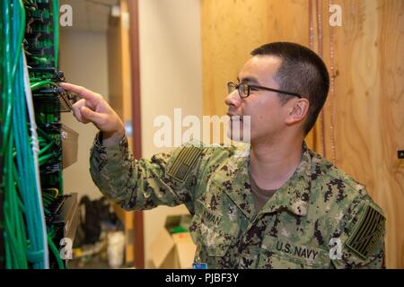 Pyeongtaek, Republik Korea (11. Juli, 2018) Information Systems Techniker 3. Klasse Thomas Kwan, U.S. Naval Computer und Telekommunikation Station Fernost Loslösung Chinhae zugeordnet, installiert an Commander, U.S. Naval Forces Korea (CNFK), Sitz in Lager Humphreys, Pyeongtaek entfernt. CNFK beendeten ihre vorwärts Hauptquartier von U.S. Army Garrison Yongsan in Seoul Umzug auf Lager Humphreys Juli 2018. Die Bewegung ist Teil der Yongsan Umzug planen und Land Partnerschaft zwischen den USA und der Republik Korea (ROK) Regierungen im Jahr 2004 unterzeichnete US-Streitkräfte zu bewegen Stockfoto