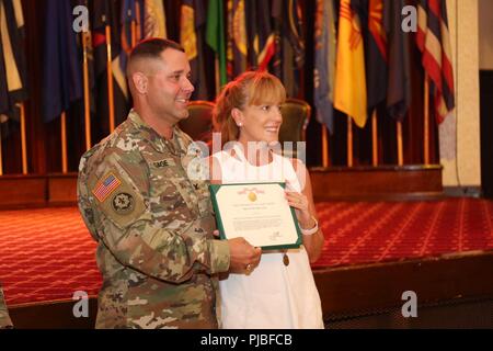 Oberst Phillip Gage, USAG Japan Commander, präsentiert Wendy Holland mit einem hervorragenden Zivildienst Award für Ihr großes Engagement und ehrenamtliche Tätigkeiten in der Gemeinschaft während eines informellen Zeremonie vor der Überlassung Ihres Mannes Verantwortung Zeremonie Juli 11, 2018, am Lager Zama Gemeinschaft Club. Ihr Ehemann, ausgehende Befehl Sgt. Maj., Holland, sagte Zeremonie Teilnehmer, Zama war das Beste duty Station, die er in seiner 32-jährigen gedient hatte - Karriere. Stockfoto