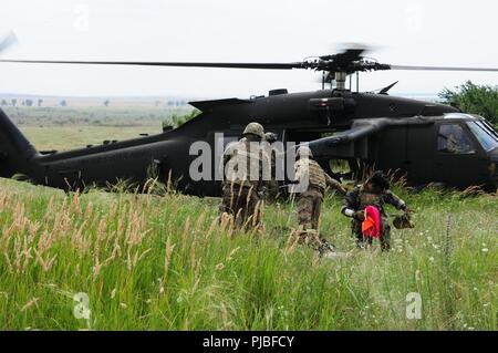 Soldaten auf den Spähtrupp, Sitz und die Konzernzentrale, 2nd Battalion, 5th Cavalry Regiment, 1st Armored Brigade Combat Team, 1.Kavallerie Division medevacs ein Soldat mit einem simulierten Verletzungen am Mihail Kogalniceanu Airbase in Rumänien, 10. Juli 2018 zugewiesen. Soldaten führte eine Air Assault Training zur Unterstützung der Atlantischen lösen, ein bleibendes Training übung zwischen der NATO und der US-Streitkräfte. Stockfoto