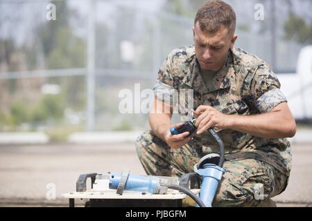 Us Marine Corps Lance Cpl. Cameron Tracy, Ingenieur Systeme Elektrik Techniker, Charlie Company, 9. Communications Bataillon, ich Marine Expeditionary Force, Reparaturen ein Power Distribution Panel an Marine Corps Base Camp Pendleton, Kalifornien, 10. Juli 2018. Tracy repariert, dass die elektrischen Anlagen der Benutzer hat feste Verbindungen für den künftigen Betrieb. Stockfoto