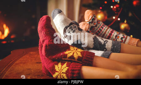 Getönten closeup Bild von Familie in Wollsocken entspannen am Kamin am Heiligabend Stockfoto