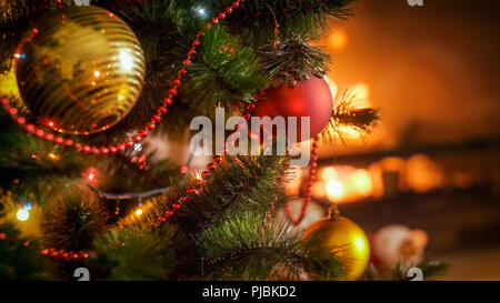 Perfektes Bild für den Winter feiern mit Weihnachtsbaum gegen brennenden Kamin im Haus Stockfoto
