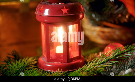 Closeup Bild der rote dekorative Laterne mit Kerze auf Feuer Baumstrukturzweig. Perfekter Hintergrund für Winterurlaub und Feiern Stockfoto