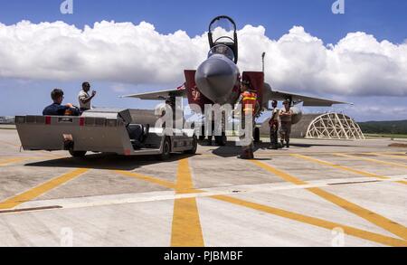 Betreuer aus dem 18 Aircraft Maintenance Squadron, Laufwerk ein Flugzeug Handler eine F-15C Eagle im schützenden Flugzeuge Schutz während der Vorbereitung für Typhoon Maria Juli 9, 2018, bei Kadena Air Base, Japan. Das Team von Kadena Betreuer bewegt Flugzeuge in Schutzeinrichtungen Schäden, die sich aus der extremen Wetter zu verhindern. Stockfoto