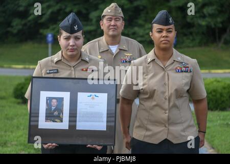 Petty Officer 3rd Class Morgan A. Hancock und Petty Officer 2nd class Jocelyn B. König präsentieren eine Ehrenmedaille Zitat zum Master Chief Petty Officer Edward C. Byers, Jr. Byers "citation wird auf dem NHCPR Ehrenmedaille Wand mit 23 anderen Empfänger platziert werden. Stockfoto