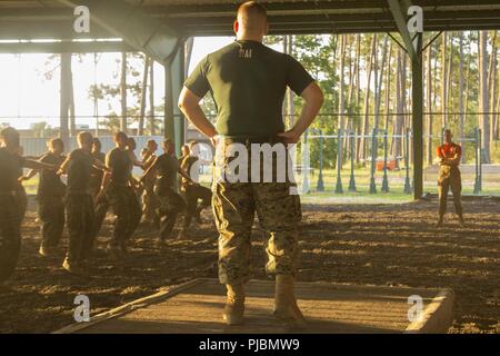 Us Marine Corps Sgt. Keegan Clark, Kampfkunstausbilder mit Unterstützung Bataillon, rekrutieren Training Regiment, überwacht Charlie Company Rekruten auf ihre Kampfkünste Techniken bei Leatherneck Quadrat auf Marine Corps Recruit Depot Parris Island, 11. Juli 2018. Das Marine Corps Martial Arts Programm hilft der Krieger ethos durch den Einsatz von bewaffneten und unbewaffneten Techniken aus verschiedenen Kampfsportarten zu erstellen Stockfoto