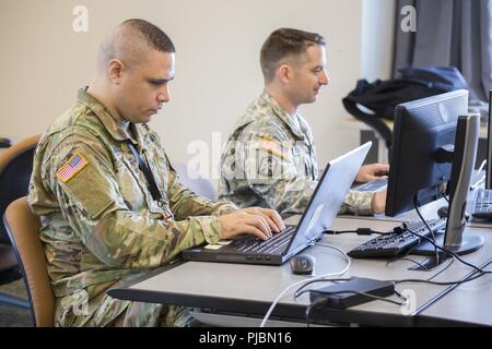 Spc. Sunia Laulile, Alpha Company, 156 Information Operations Battalion, 56th Theater Information Operations, und Sgt. 1. Klasse Samuel Anderson, Joint Force Headquarters, Washington National Guard, der Arbeit ein Netzwerk als gegnerische Streitmacht während der Internationalen Stiftskirche Cyber Defense Einladungs, 6. Juli 2018 zu verstoßen, bei Highline Community College in Des Moines, Washington Washington National Guard Soldaten nahmen an der Internationalen Stiftskirche Cyber Defense Einladungs zu helfen, Informationstechnologie Studenten auf ihre Antworten auf Cyberangriffe erziehen. Stockfoto