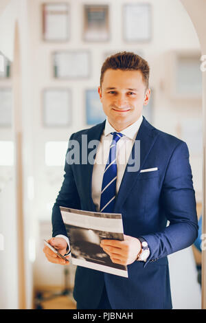 Ein junger und erfolgreicher Mann steht in einem blauen Anzug Stockfoto