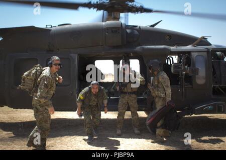 Gen. Chiya, Kommandant der syrischen Demokratischen Kräfte in Syrien naher Fluss Euphrat Valley, verlässt das Flugzeug nach seinem ersten UH-60 Blackhawk Flug mit US-Armee Generalmajor James B. Jarrard, Kommandeur der Special Operations Joint Task Force-Operation inhärenten Lösen, in Syrien, 11. Juli 2018. Gen. Chiya met mit Koalitionsspitzen den Fortschritt der Operation Roundup und die Niederlage - ISIS Mission zu diskutieren. Stockfoto