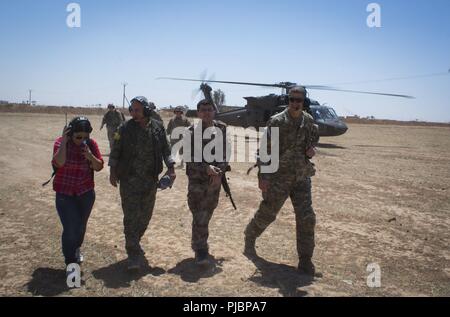 Gen. Chiya, Kommandant der syrischen Demokratischen Kräfte in Syrien naher Fluss Euphrat Valley, und US-Armee Generalmajor James B. Jarrard, Kommandeur der Special Operations Joint Task Force-Operation inhärenten lösen, gehen zusammen, wie Sie die Ausfahrt ein UH-60 Blackhawk am 11. Juli 2018. Die Koalition Generäle met mit Gen. Chiya der Fortschritt der Operation Roundup, das SDF zu diskutieren - LED-Mission zu ISIS im Nordosten von Syrien zu zerstören. Stockfoto