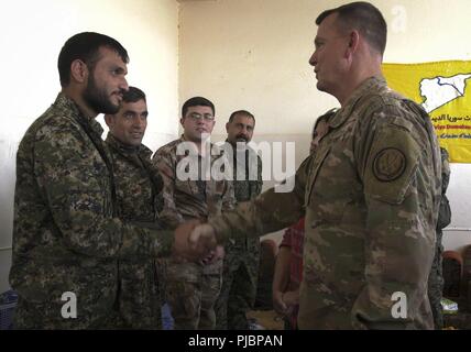 Us-Armee Generalleutnant Paul E. Funk, Kommandeur der Combined Joint Task Force-Operation inhärenten Lösen, schüttelt Hände mit einem syrischen Demokratischen Kräfte Soldat eine Münze für seine Handlungen der Distinguished Service im Kampf gegen ISIS, 11. Juli 2018. Generalleutnant Funk fragte jeden SDF Soldat, warum Sie freiwillig den Kampf zu besiegen, ISIS und befreien Syrien verbunden. Stockfoto