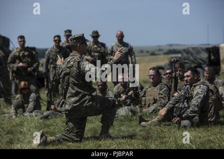 Us Marine Corps Kapitän James Ayule, der kommandierende Offizier der Echo-Akku, 2. Bataillon, 10 Marine Regiment (2/10), 2nd Marine Division, spricht mit seinem Marines in Salisbury, England, Juli 2, 2018. Marines mit der Unit durchgeführt live-fire Übungen mithilfe der M777 Haubitze während der Übung grüne Kanone 18. Grüne Kanone ist eine multinationale Übung mit US-Marines die Möglichkeit, Taktiken und Techniken sowie zu Exchange Projekt Letalität und Combat Power auf der ganzen Welt neben Partner Nationen. Stockfoto