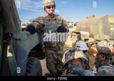 FORT HUNTER LIGGETT, Kalifornien - Sgt. Michael Jurczak, ein Beobachter, Controller/Trainer (OC/T) mit dem 2/378 th OC/T Bataillon, Lächeln auf, als er die Soldaten die Ausbildung ist ihre Bekämpfung Lebensretter Übung auf Fort Hunter Liggett, 12. Juli 2018 durchzuführen. Jurczak zugewiesen wird, hat der 890th Transportation Co ICTC, von Logan, Utah zu trainieren während der jährlichen Combat Support Training (CSTX). Stockfoto