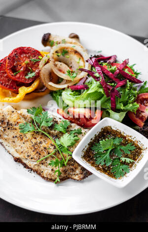 Tilapia Fischfilet mit gemischter Salat gegrilltes Gemüse und Kräuter-Vinaigrette Sauce Stockfoto