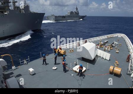 Pazifik (14 Juli 2018) Besatzungsmitglieder an Bord der U.S. Coast Guard Cutter WMSL Bertholf (750) griff Linien an den Militärischen Sealift Command hilfs Dry Cargo und Munition ship USNS Carl Brashear (T-AKE 7) während der BETANKUNG-auf-See, 14. Juli, während die betankt Japan Maritime Verteidigung-kraft Zerstörer Hubschrauber Schiff JS Ise (DDH182) eine Routine brechen weg führt. Bertholf, Brashear und Ise sind an den Rand des Pazifik (Rimpac) Übung. 25 Nationen, 46 Schiffe und fünf U-Boote, über 200 Flugzeuge und 25.000 Angestellte beteiligen sich an Rimp Stockfoto