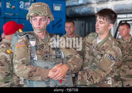 Kansas Air National Scots Guards Master Sgt. Michael Ashurst, Kansas Air National Guard Operationen Betriebsleiter des 284 Air Support Operation Squadron, Salina, Kansas, führt einen Sprung-master Personal Inspektion auf SPC. Jakob Engstrom der Georgia Army National Guard 165 Quartermaster Unternehmens, von General Lucius D. Clay National Guard Zentrum, Marietta, Georgia, als Soldaten und Piloten für Ihre airborne Operations bei Augusta Regional Airport, Georgia, 14. Juli 2018 vorbereiten. Stockfoto