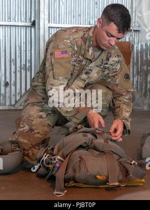 Georgia Armee nationale Scots Guards, Sgt. Dawson Aaron, mit Rädern Vechile Mechaniker der 165 Quartermaster Unternehmens, von General Lucius D. Clay National Guard Zentrum, Marietta, Georgia, prüft seine MC-6 Fallschirm als Soldaten und Piloten bereiten sich für ihren Airborne Operations bei Augusta Regional Airport, Georgia, 14. Juli 2018. Stockfoto