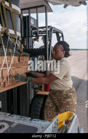 Air Force Reserve Staff Sgt. Natisha Lee von der 94th Airlift Wing, Dobbins Air Reserve Base, Marietta, Georgia lädt eine verbesserte Container Delivery System auf eine C-130 als Georgien Scots Guards aus Die 165 Quartermaster Unternehmens, von General Lucius D. Clay National Guard Zentrum, Marietta, Georgia, betreibt die Gabelstapler als Soldaten und Piloten für Ihre airborne Operations bei Augusta Regional Airport, Georgia, 14. Juli 2018 vorbereiten. Stockfoto