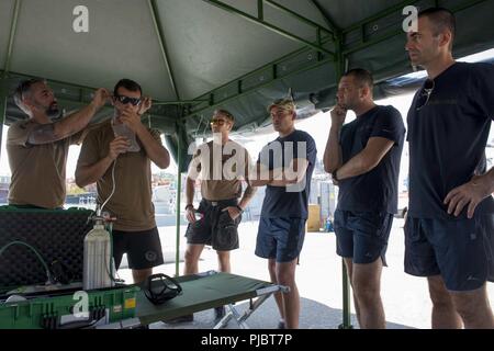 ODESSA, Ukraine (12. Juli 2018) Royal Canadian Navy Petty Officer 1st Class Blair Tobin und Royal Canadian Navy führenden Seaman Dylan Parker, sowohl für die Flotte Tauchen Einheit Atlantic zugewiesen wurden, demonstrieren, wie eine Sauerstoffflasche bei Diver Emergency Evacuation Schulungen für übung Sea Breeze 2018 in Odessa, Ukraine, 12. Juli 2018 zu verwenden. Sea Breeze ist eine in den USA und der Ukraine gemeinsam Multinationale maritime Übung im Schwarzen Meer statt und wurde entwickelt, um die Interoperabilität der beteiligten Nationen zu verbessern und die Sicherheit im Seeverkehr in der Region zu stärken. Stockfoto