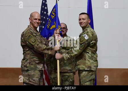 Oberst Scott Gibson, 407 Air Expeditionary Gruppenkommandant und Vorsitzende akzeptiert die 407 Expeditionary Sicherheitskräfte Squadron guidon von Maj. Aaron Gulczynski bei einem Befehl Zeremonie an einem geheimen Ort im Südwesten Asien, 15. Juli 2018. Gulczynski Befehl des Geschwaders zu Maj. Roger Howard aufgegeben. Stockfoto