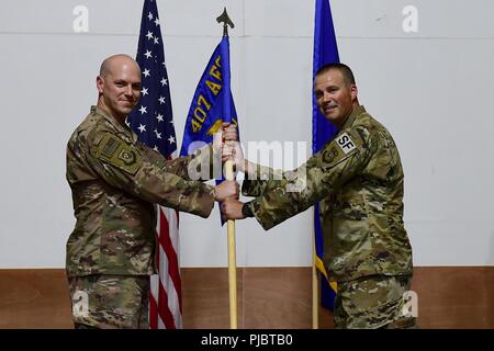 Oberst Scott Gibson, 407 Air Expeditionary Gruppenkommandant und Presiding Officer, präsentiert die 407 Expeditionary Sicherheitskräfte Squadron guidon, Maj. Roger Howard bei einem Befehl Zeremonie an einem geheimen Ort im Südwesten Asien, 15. Juli 2018. Maj. Aaron Gulczynski Befehl des Geschwaders zu Howard während der Zeremonie verzichtet. Stockfoto