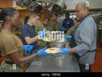 (3. Juli 2018) Segler der Nimitz-Klasse Flugzeugträger USS George Washington (CVN 73) und Jody Gholson (rechts), die Küche der Halbinsel Rescue Mission Mahlzeiten vorbereiten, während die ehrenamtliche Mitarbeit in der Halbinsel Rescue Mission in Newport News. Stockfoto