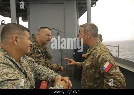 Der chilenischen Marine Kapitän Jorge Keitel, rechts, ein Sonderberater mit speziellen Zweck Marine Air-Ground Task Force - südliche Befehl, spricht mit US Marine Sgt. Maj. Adam N. Sheinkin, der Sergeant Major von SPMAGTF-SC, und dem Kolumbianischen Marine Infanterie Oberstleutnant Erick Del Rio, der stellvertretende Kommandeur der SPMAGTF-SC, während einer Tour von der USS Gunston Hall (LSD 44) Rolling flugwerke Rakete und schließen - in Waffen System, 14. Juli 2018. Die Tour war der Führer der SPMAGTF-SC gegeben, ein besseres Verständnis der Funktionen des Gunston Hall zu geben. Die Marinesoldaten und Matrosen von SPMAGTF - SC sind die Durchführung von Security Coo Stockfoto