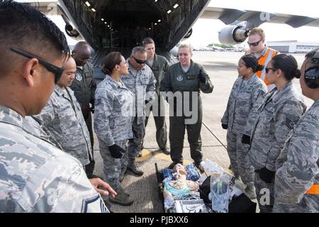 Us Air Force Maj. Venus Victorino, ein Mitglied der Critical Care Air Transport Team mit der 943Rd Luft- und Raumfahrtmedizin Squadron, diskutiert kritisch-care Patient Transportation mit Aeromedical Staging 624th Squadron Personal an der U.S. Coast Guard Air Station Friseure, Hawaii, 10. Juli 2018, während der Pacific Lifeline 2018. Pacific Lifeline 2018 ist eine landesweite medizinische Übung in Hawaii durchgeführt als Teil eines größeren 2018 Rand der Pazifischen Übung. Die 624Th ASTS bietet medizinische Unterstützung für die regionalen 624th Support Group, die Aufsicht über die einzelnen Gesundheit und medizinische Bereitschaft und Stockfoto