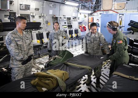 Us Air Force Staff Sgt. Jodi Signer, ein Ausbilder von der 446th Aeromedical Evacuation Squadron, vertraut gemacht Aeromedical Staging 624th Squadron Personal mit Patienten Ausrüstung an Bord eines US Air Force C-17 Globemaster III Flugzeuge bei der U.S. Coast Guard Air Station Friseure, Hawaii, 10. Juli 2018, während der Pacific Lifeline 2018. Pacific Lifeline 2018 ist eine landesweite medizinische Übung in Hawaii durchgeführt als Teil eines größeren 2018 Rand der Pazifischen Übung. Die 624Th ASTS bietet medizinische Unterstützung für die regionalen 624th Support Group, die Aufsicht über die Gesundheit des Einzelnen und der Medizinischen readin Stockfoto