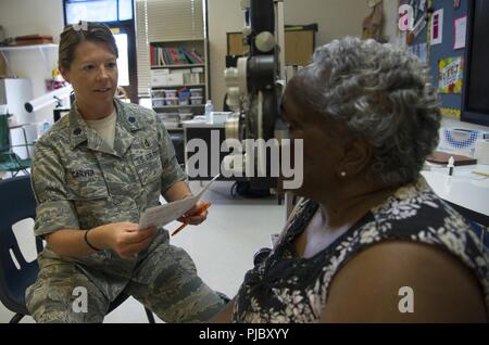 Us Air Force Oberstleutnant Jennifer Carver, von Savannah, GA., ein Augenarzt für 165 Luftbrücke Flügel der Georgia Air National Guard, Medical Group, führt eine Augenuntersuchung für eine lokale Bürger während der East Central Georgia Innovative Readiness Training in Ramsau, Ga, 13. Juli 2018. Das IRT bietet praktische, reale Ausbildung Bereitschaft und Interoperabilität für Service Mitglieder in komplexen Umgebungen mit Kontingenz wesentliche Dienstleistungen für amerikanischen Gemeinschaften zu verbessern. Stockfoto