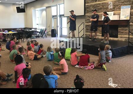 GRAND RAPIDS, Mich (13 Juli 2018) - Leiter der Luftfahrt Bootsmann Mate (Ausrüstung) Jeremy Stoecklein, links, von Hutchinson, Kansas, USS Gerald R. Ford's (CVN 78) Luft Abteilung zugewiesen, religiösen Programm Specialist 2. Klasse Chris Atwood, aus Livonia, Michigan, USS Gerald R. Ford's (CVN 78) Befehl religiösen Dienst Abteilung zugewiesen, und Leutnant Sarah Brower, von Grand Haven, Michigan, zugeordnet zu den USS Gerald R. Ford's (CVN 78) Medizinische Abteilung mit Kindern während einer Community Relations bei der Heilsarmee und Ray Kroc Corps Community Center sprechen. Ford Matrosen waren im Grand Stockfoto