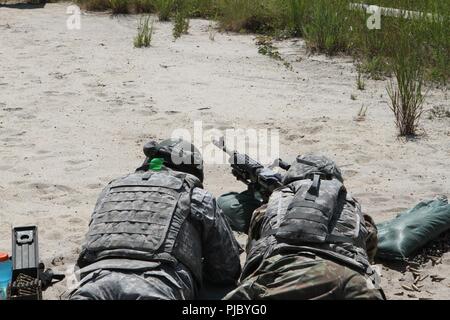 U.S. Army Reserve Soldaten nehmen eine anfällig gegen Position hinter einer M240B Light Machine Gun an einem heißen Sommertag im Betrieb Cold Steel II, die von der US-amerikanischen Armee die zivilen Angelegenheiten und psychologische Funktion Befehl an Joint Base Mc Guire-Dix - Lakehurst, New Jersey, 11. Juli 2018 veranstaltet. Betrieb Cold Steel ist der US-Armee finden Crew - Serviert Waffen Qualifizierung und Validierung Übung, um zu gewährleisten, dass America's Army Reserve Einheiten und Soldaten ausgebildet sind und bereit, kurzfristig zu implementieren und überall in der Welt bekämpfen - bereit und tödlichen Feuerkraft zur Unterstützung der Armee und unsere gemeinsamen Partner bringen Stockfoto